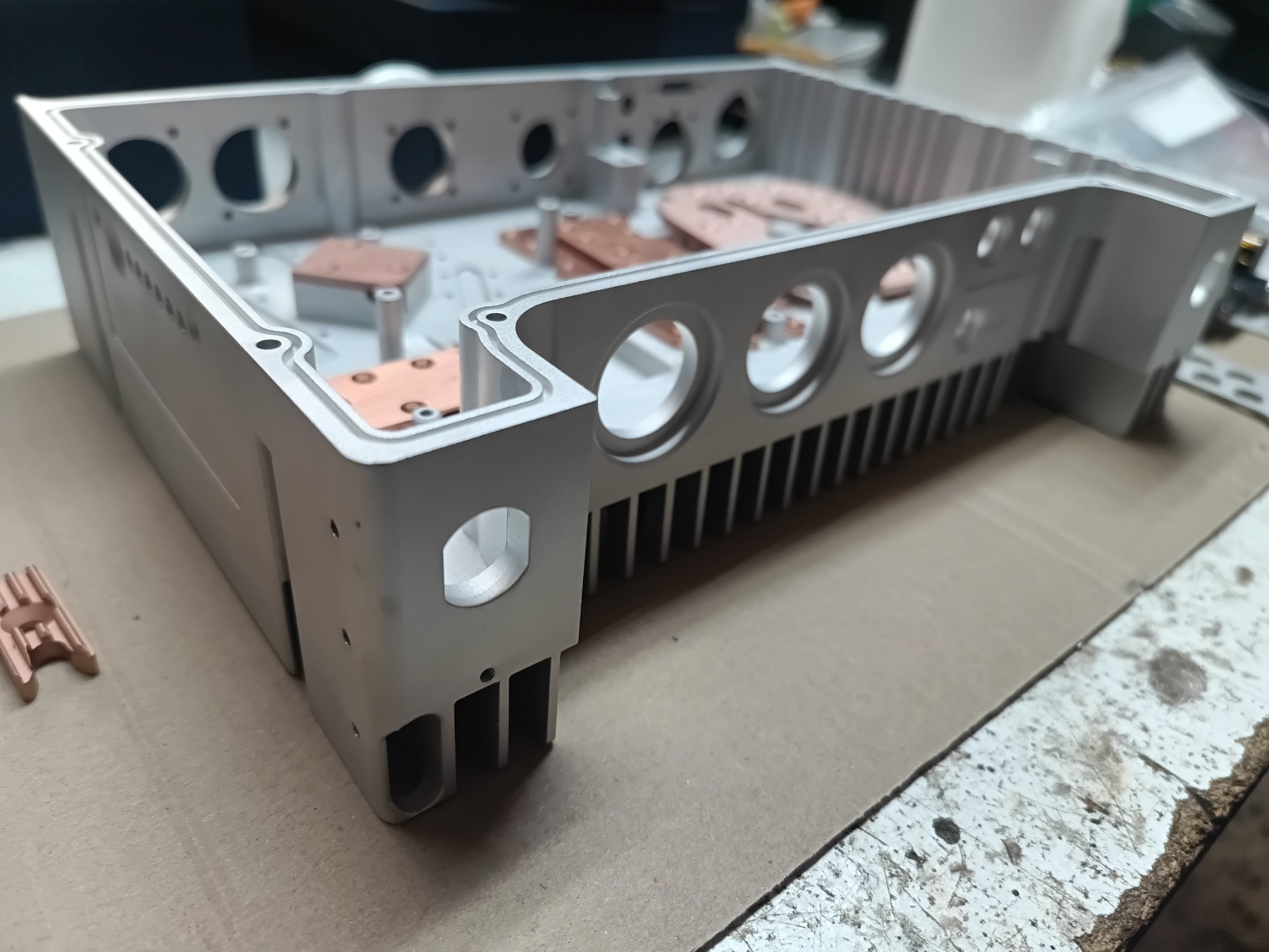CNC-machined aluminium electronics enclosure with integrated heatsink fins and copper heat spreaders